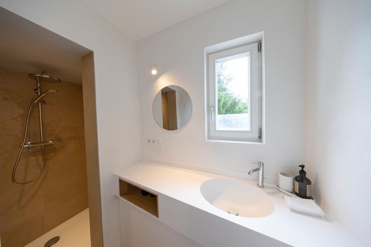 Badezimmer mit Dusche, Waschbecken und Fenster