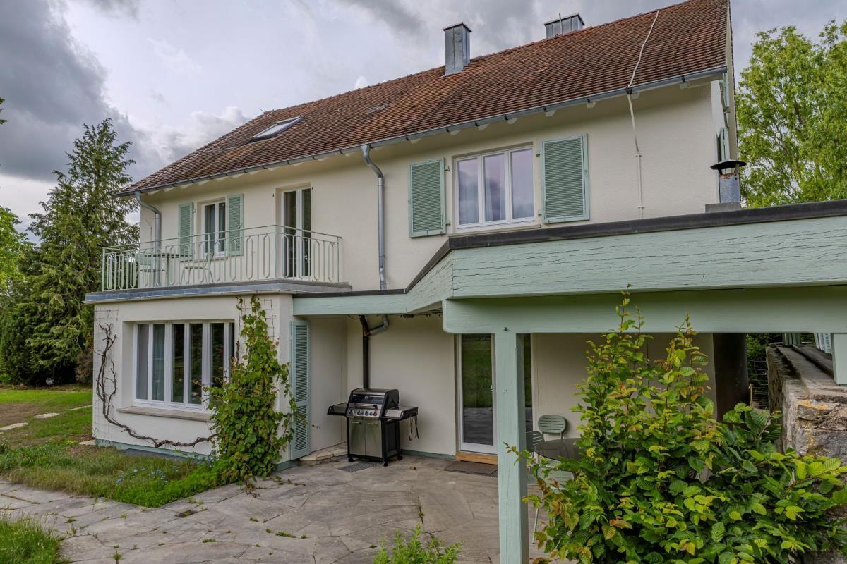 Haus mit Balkon, Grill und Terrasse in grüner Umgebung