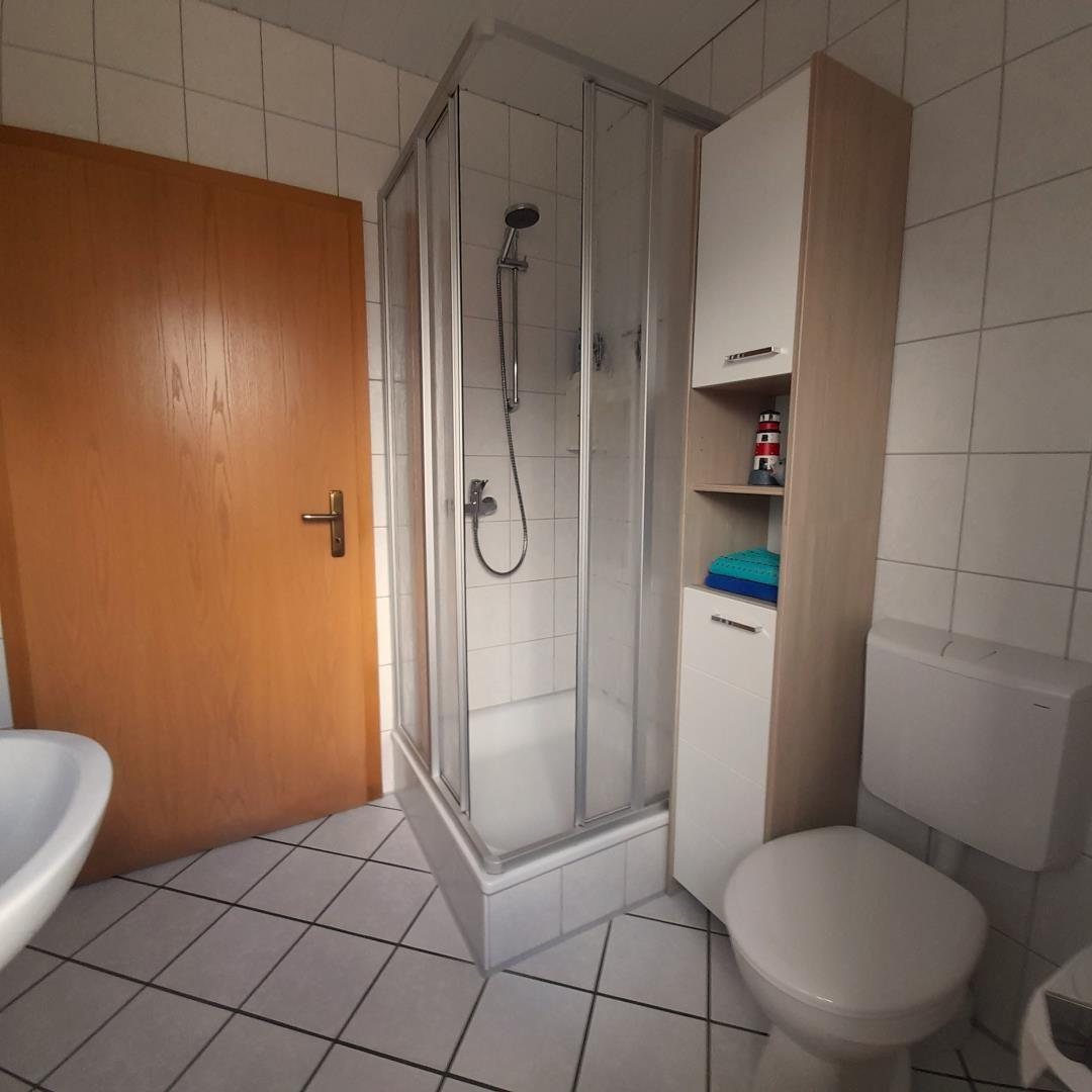Bathroom with shower, toilet, and sink.