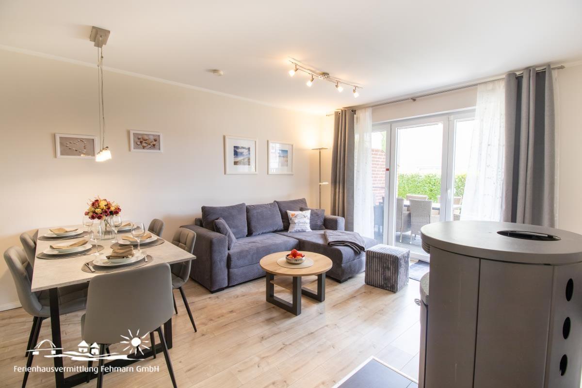 Wohn- und Essbereich mit Sofa, Esstisch und Balkonzugang.