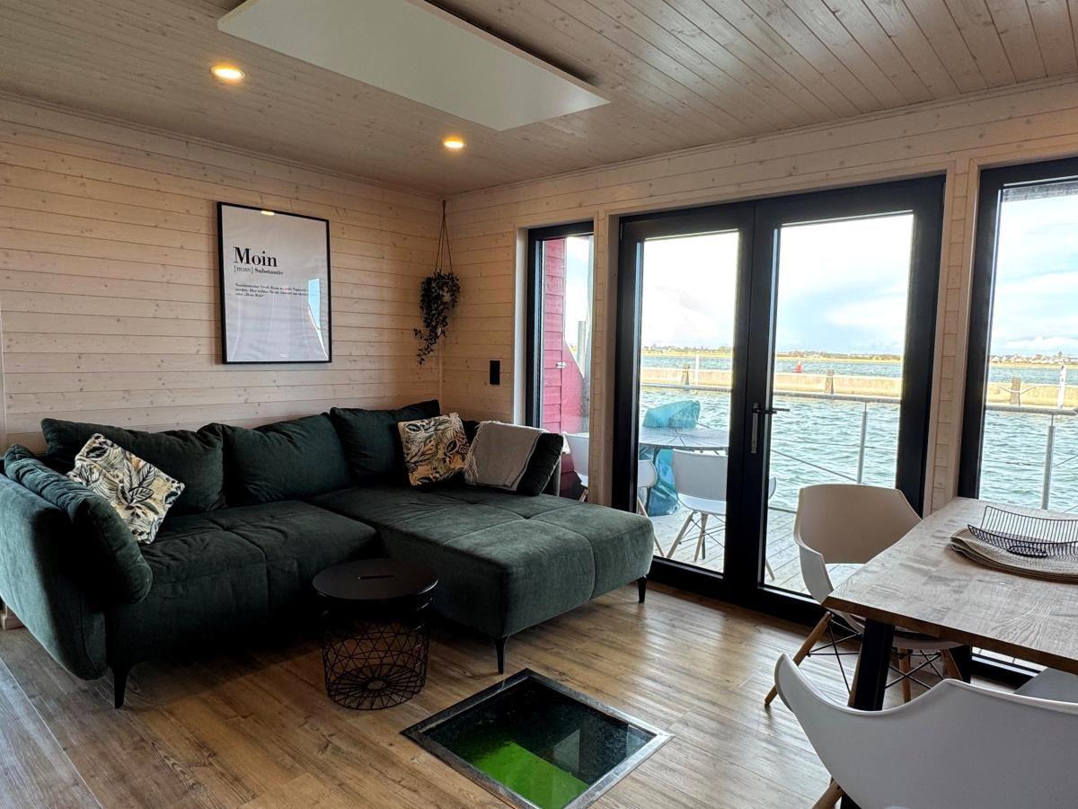 Wohnbereich mit Sofa, Tisch und Blick auf Wasser