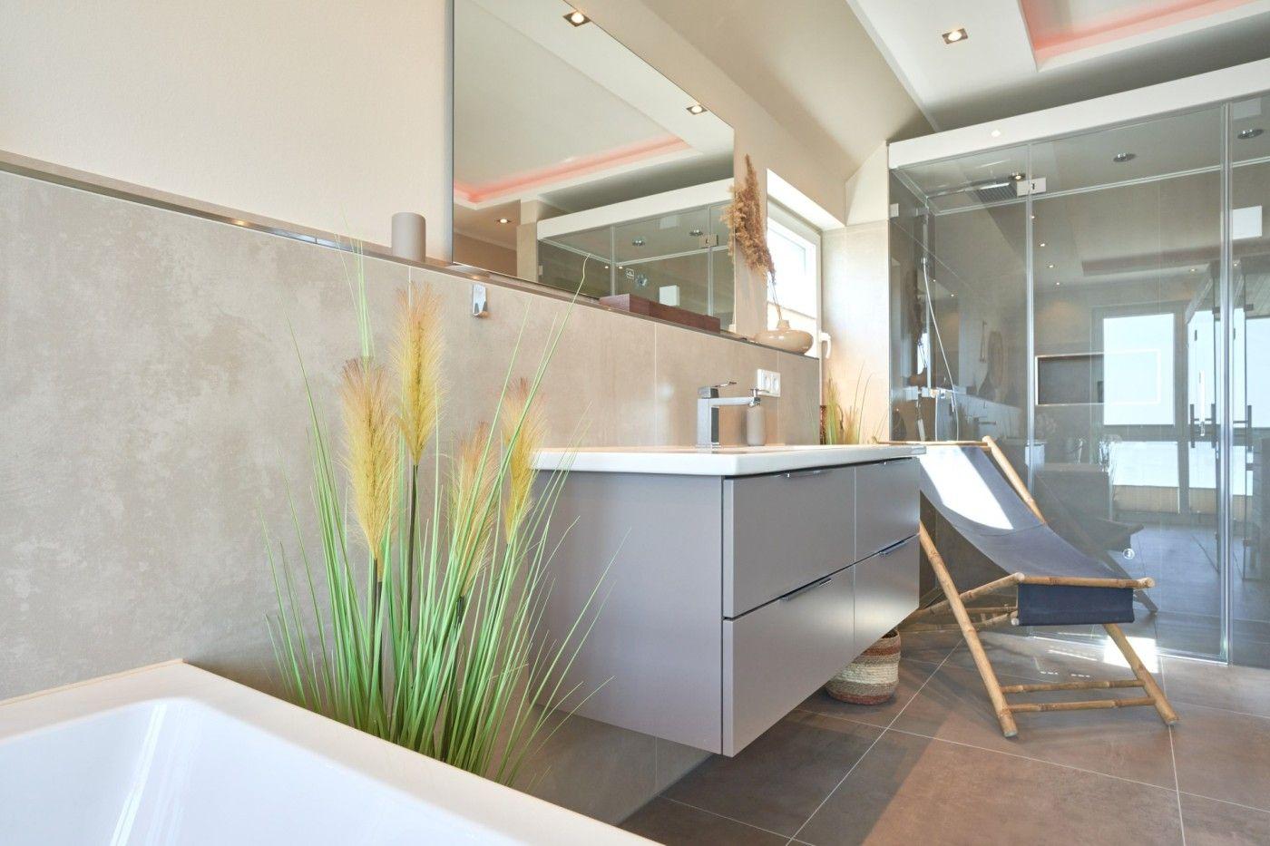 Badezimmer mit Waschtisch, Spiegel, Dusche und Liegestuhl