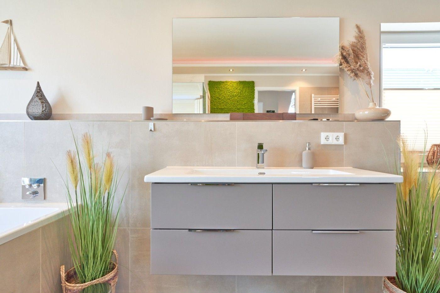 Badezimmer mit Waschbecken, Spiegel und Pflanzen