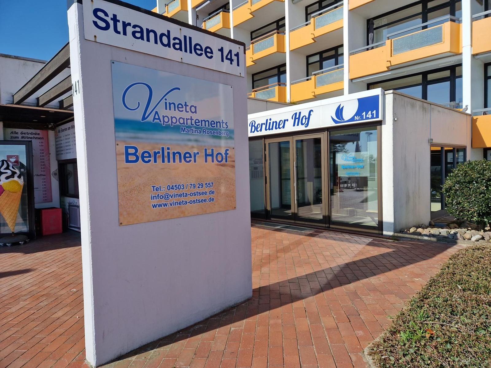 Eingangsbereich von Vineta Appartements Berliner Hof mit Schild und Glasfront.
