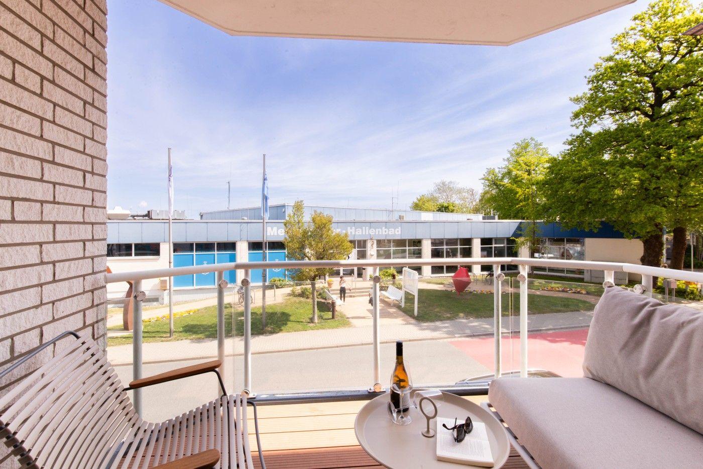 Terrasse mit Sitzgelegenheiten und Blick auf Hallenbad.