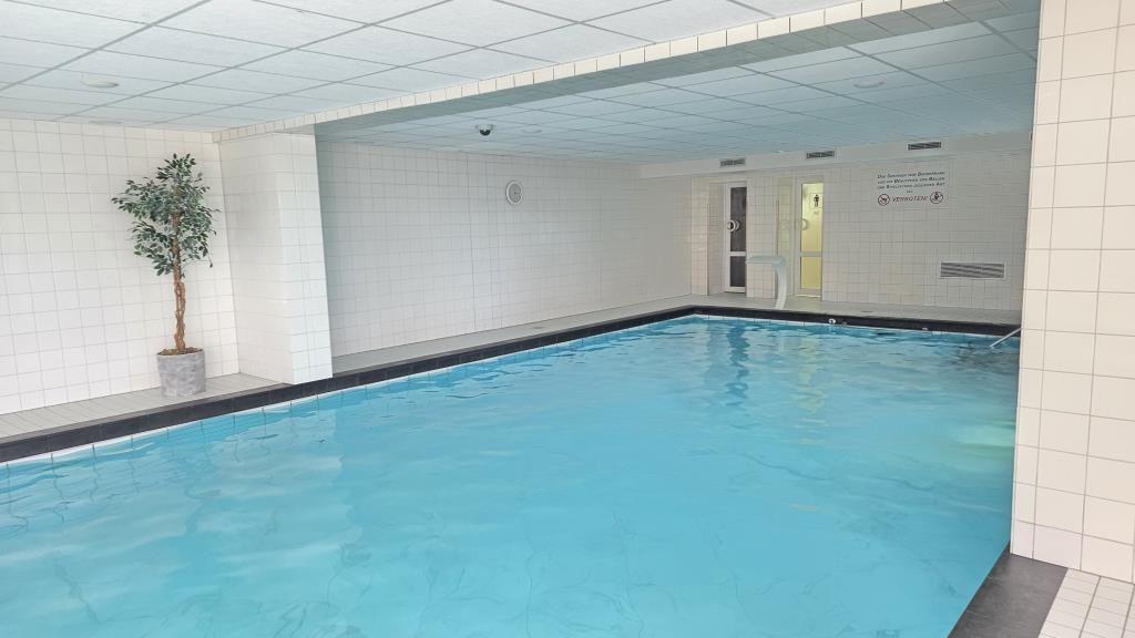 Innere Schwimmhalle mit Pool, Wand und Pflanze