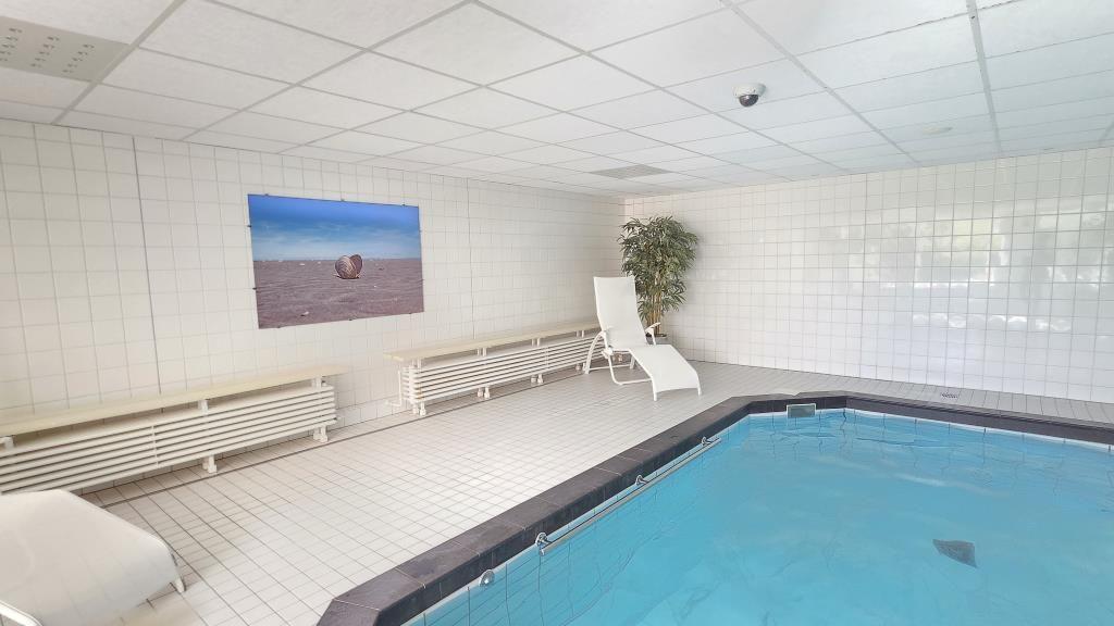 Innenpool mit Liegestühlen und Wandbild