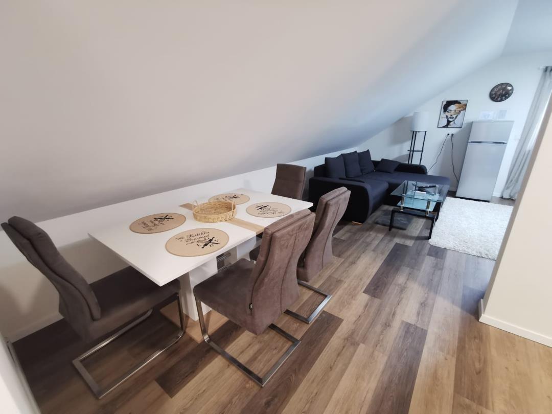 Essbereich mit Tisch und Stühlen, Wohnbereich mit Sofa und Kühlschrank