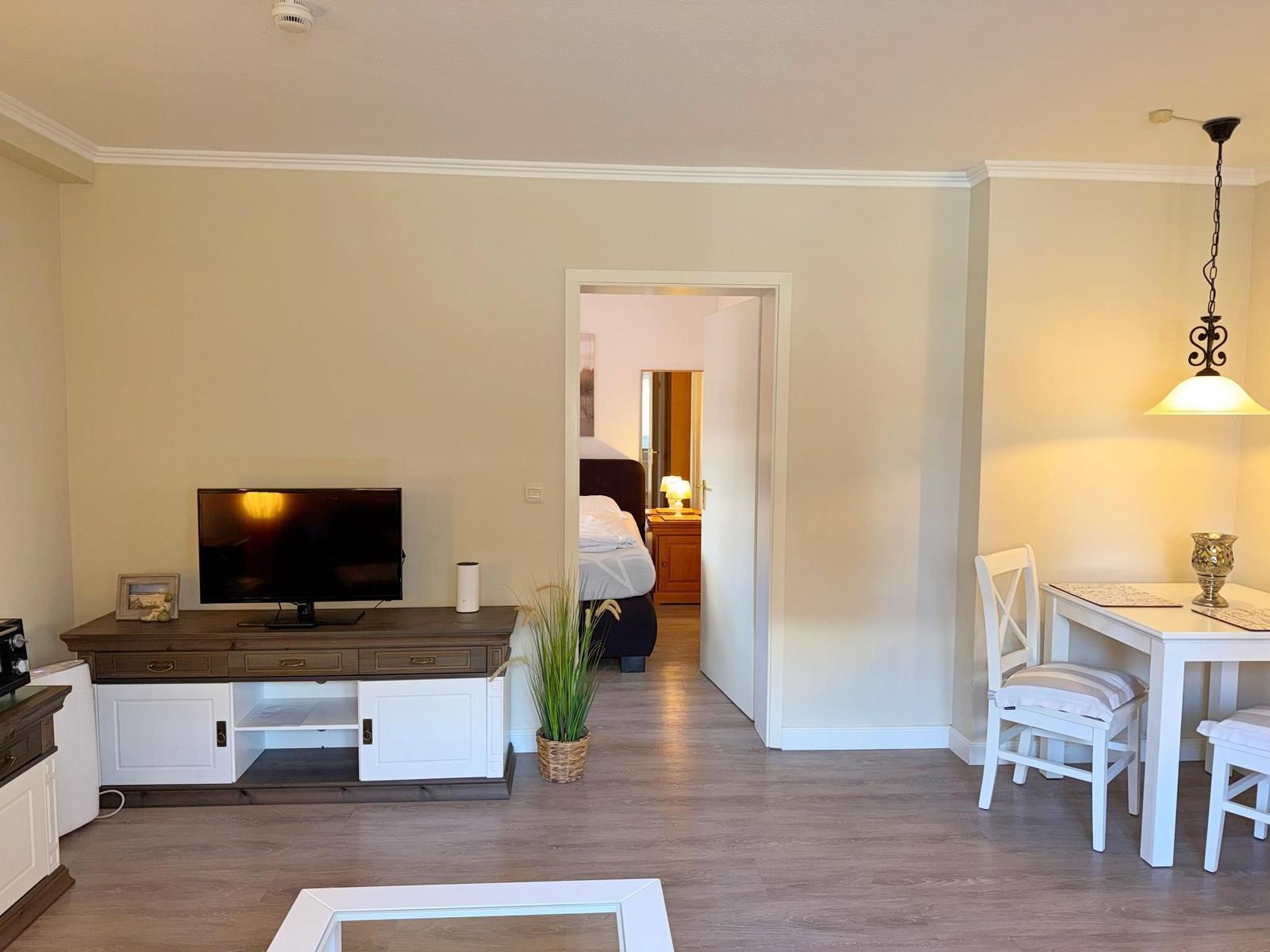 Wohnbereich mit TV, Essplatz und Blick in Schlafzimmer.