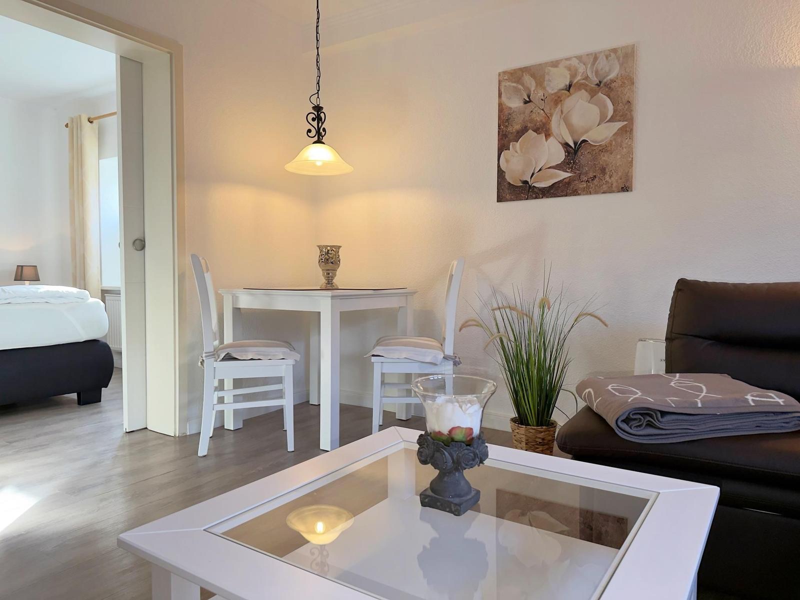 Wohnzimmer mit Essbereich, Sofa und Blick in Schlafzimmer.