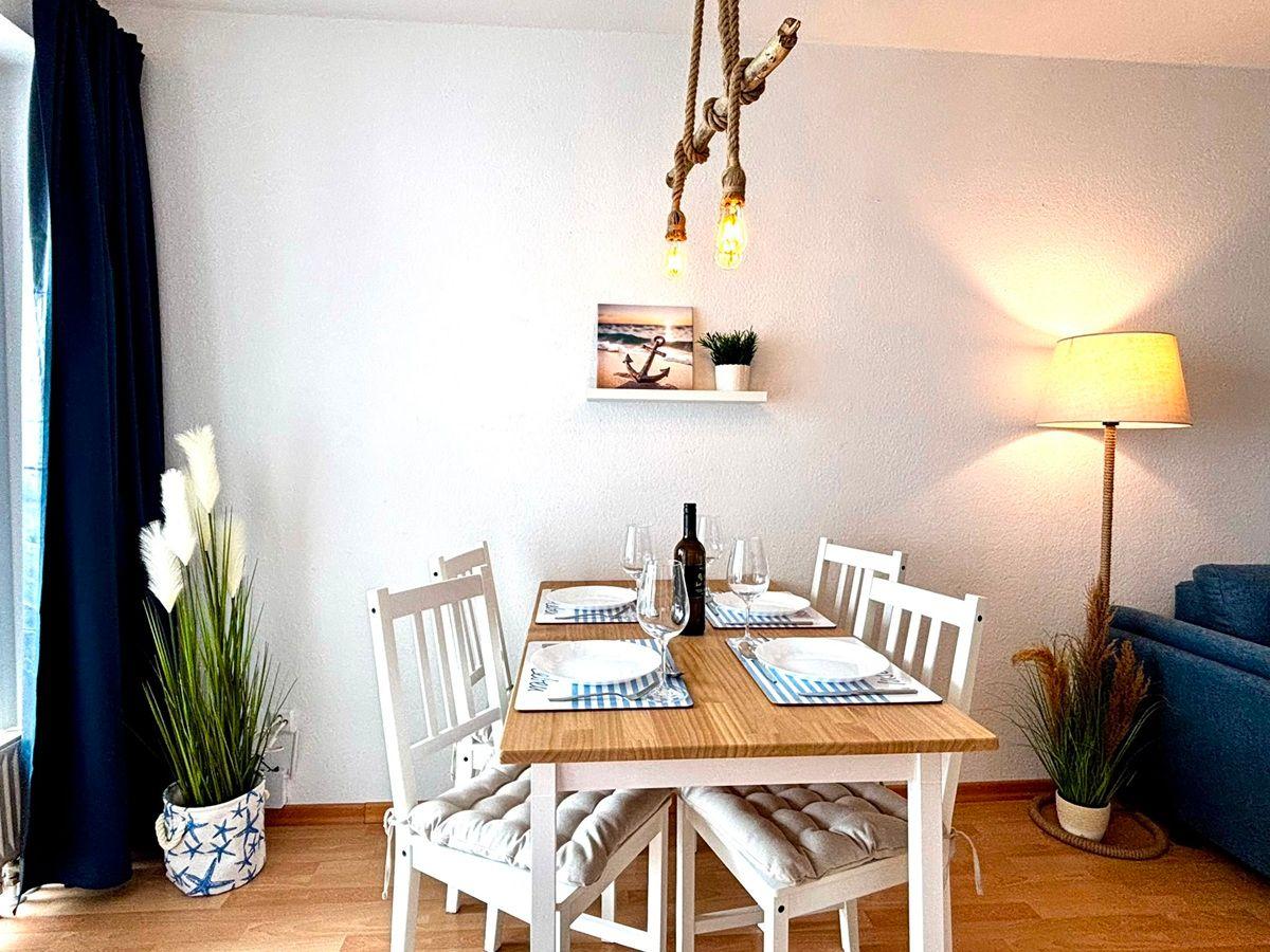 Esszimmer mit Holztisch, weißen Stühlen und Sehenswerten Dekoration.