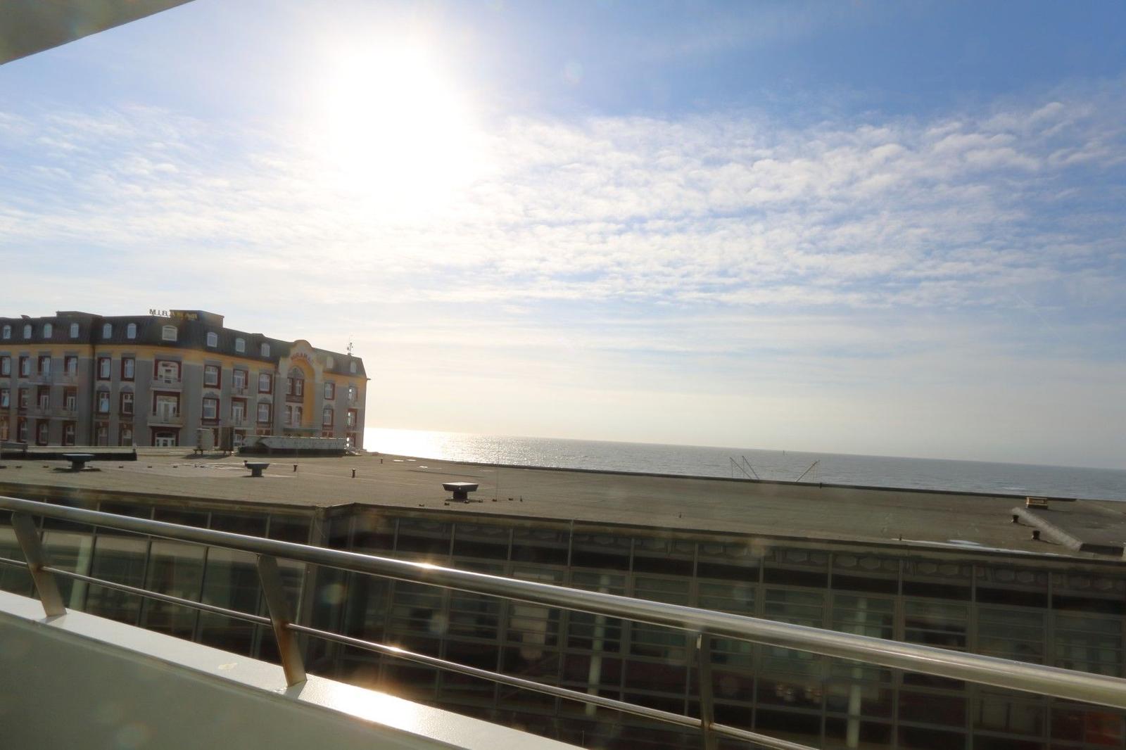 View of the sea and a building from the terrace.