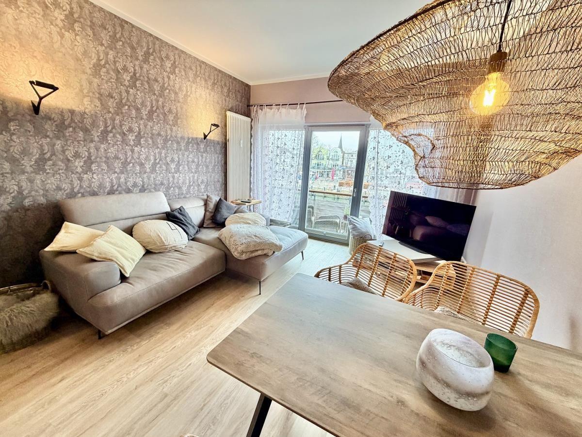 Wohnzimmer mit Sofa, Esstisch und Balkonansicht