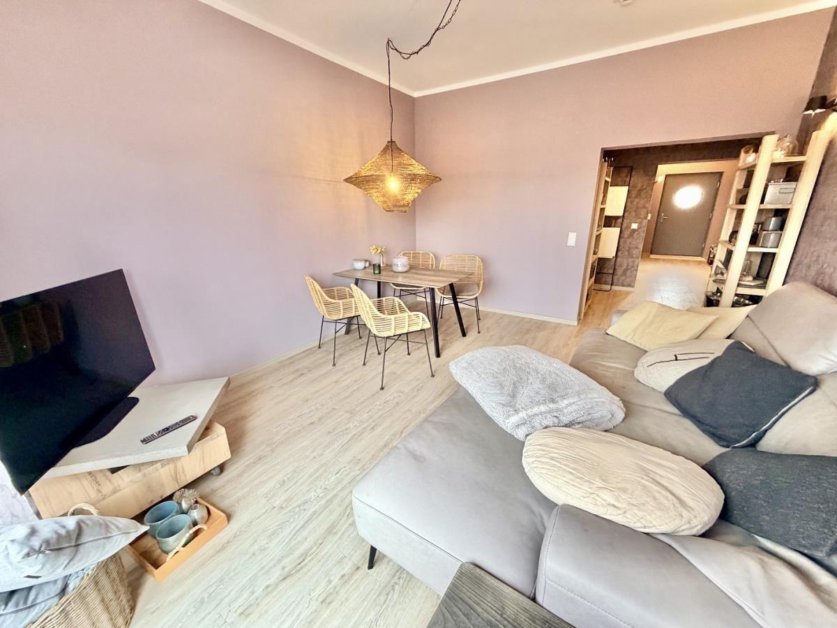 Wohn- und Essbereich mit Sofa, Esstisch und Fernseher.