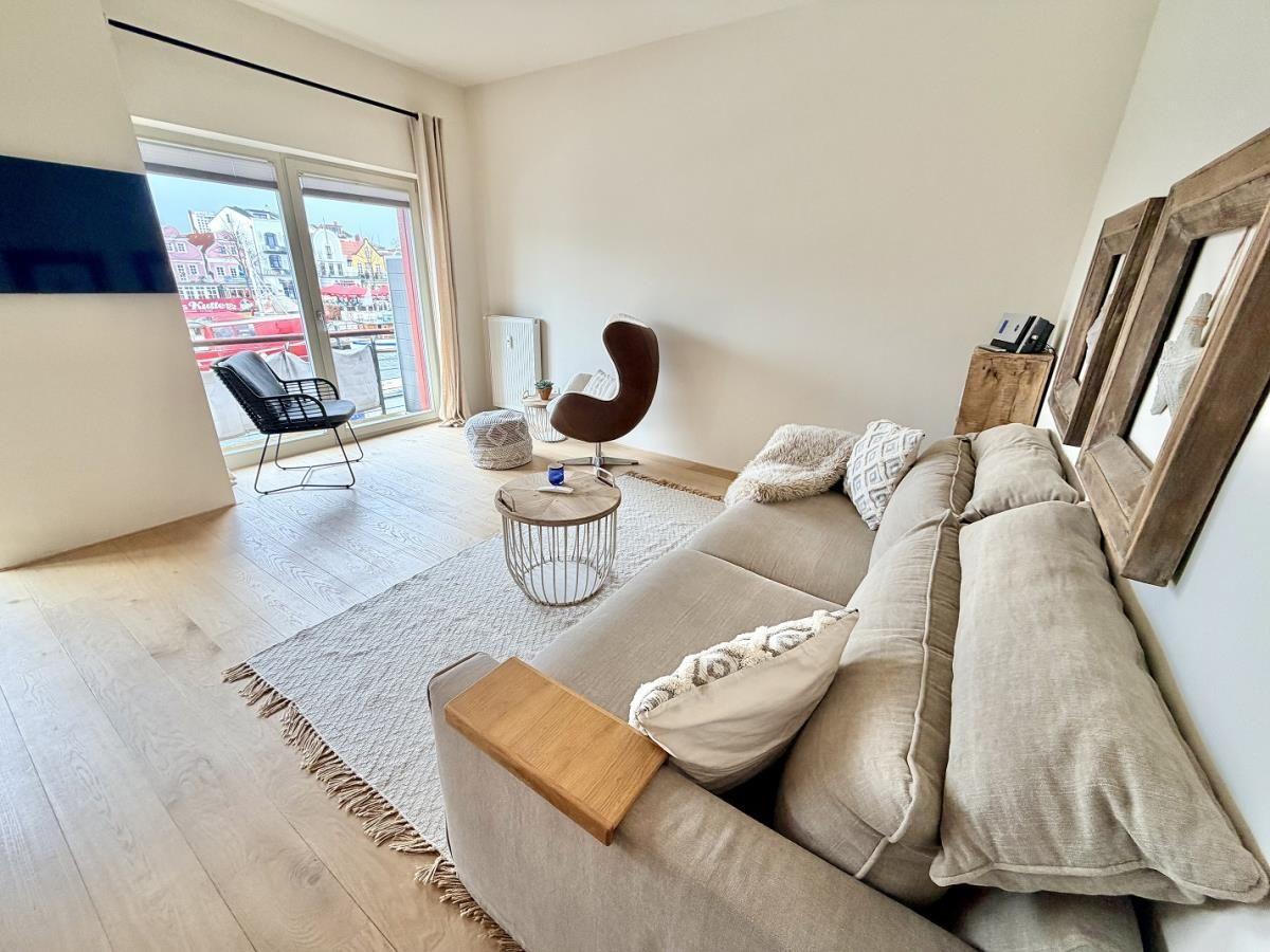 Wohnzimmer mit Sofa, Couchtisch und Blick auf Hafen.