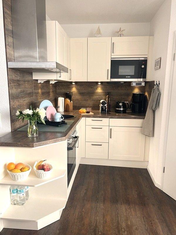 Kitchen with white cabinets, dark wood flooring, and stainless steel stove.