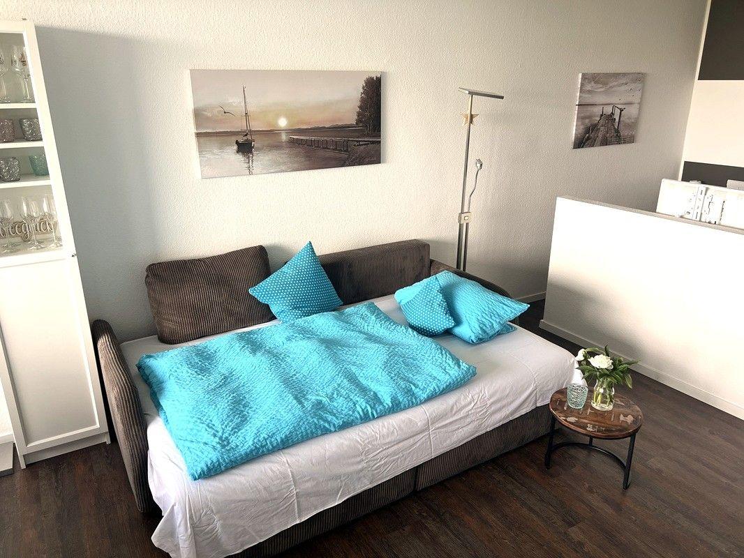 Bedroom with bed, wall art, and small table with flowers.