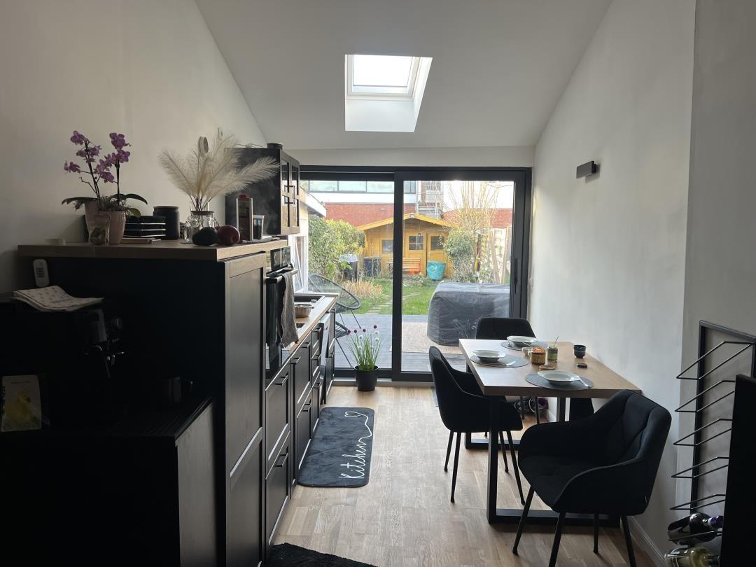 Küche mit Esstisch, Schiebetür zum Garten und Dachfenster.