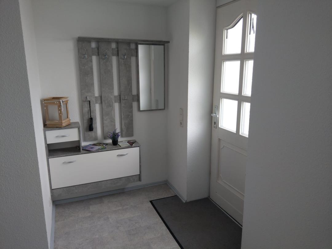 Eingangsbereich mit Garderobe, Spiegel und Tür