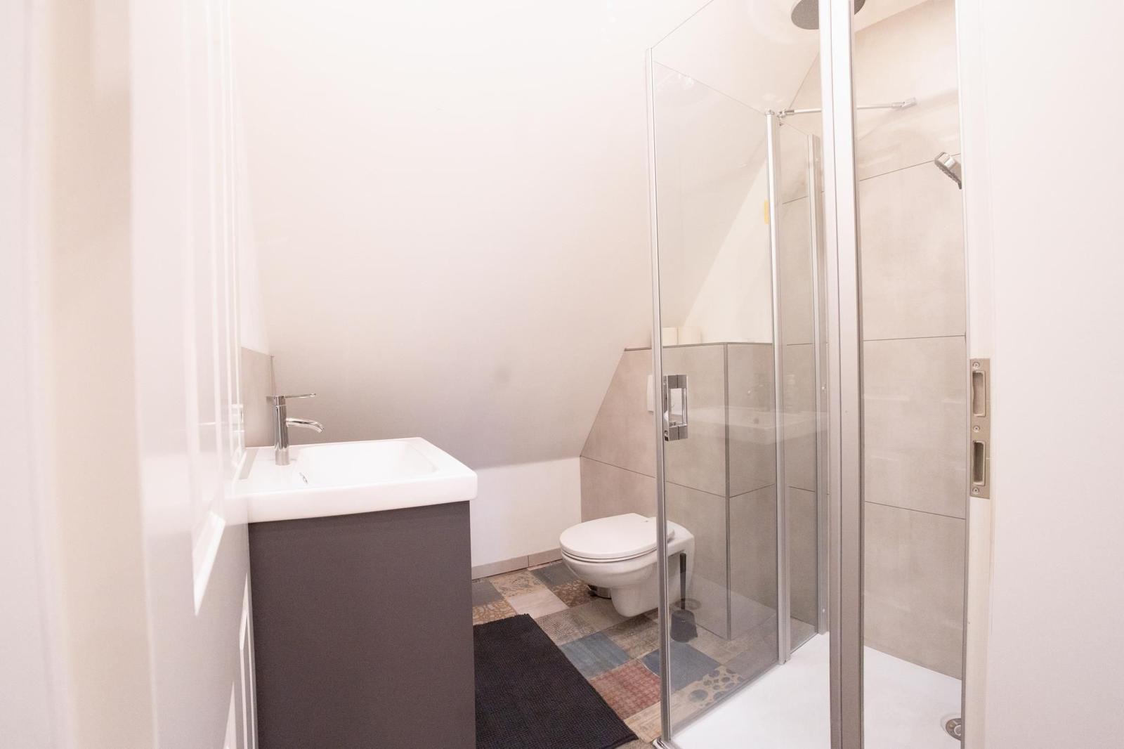 Badezimmer mit Dusche, Toilette und Waschbecken.