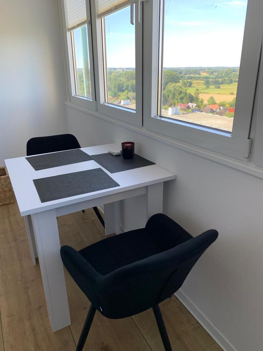 Esstisch mit zwei Stühlen und Blick auf Landschaft.