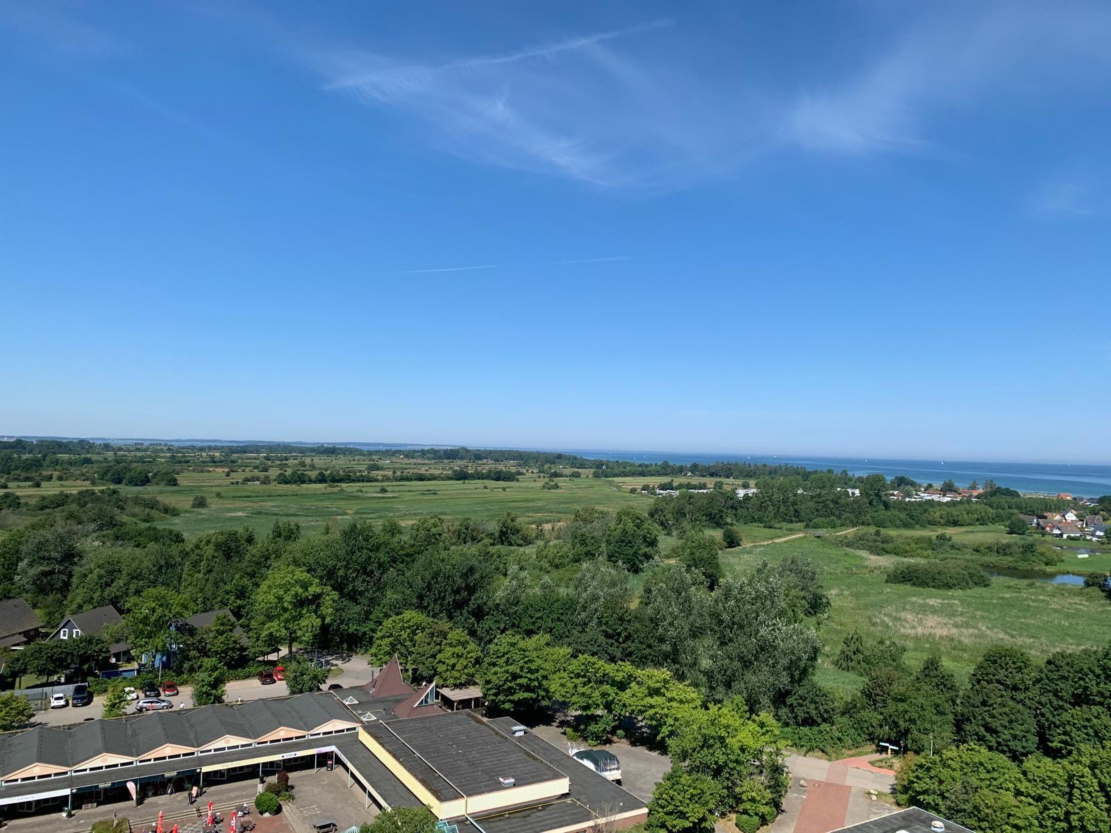 Panoramablick auf grüne Landschaft und See unter blauem Himmel