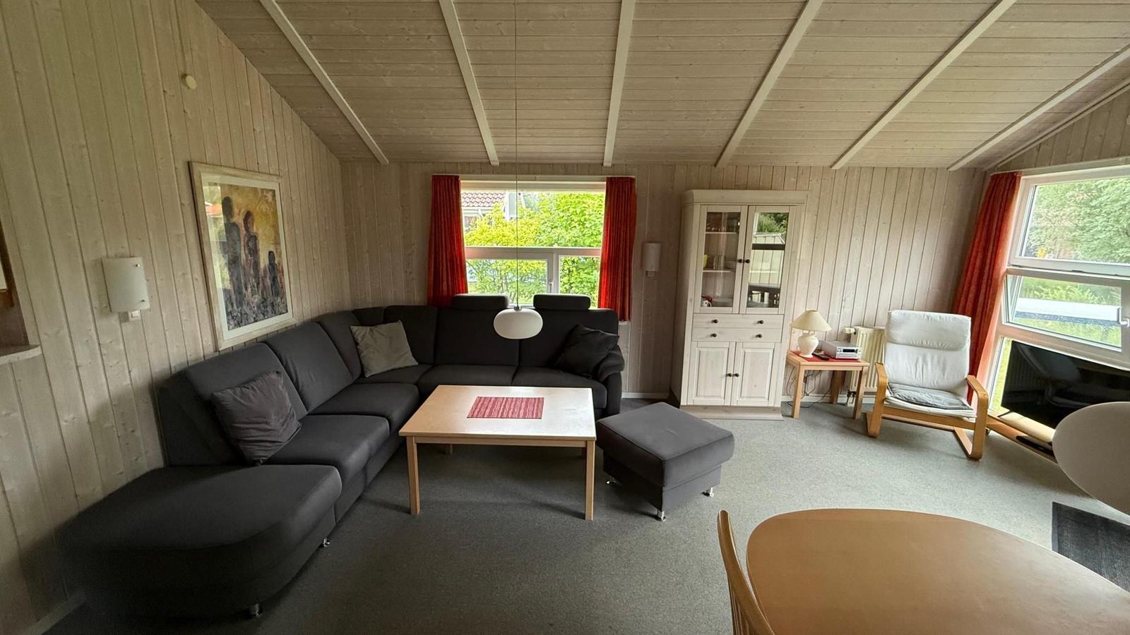 Living room with gray sofa, wooden table, and white furniture.