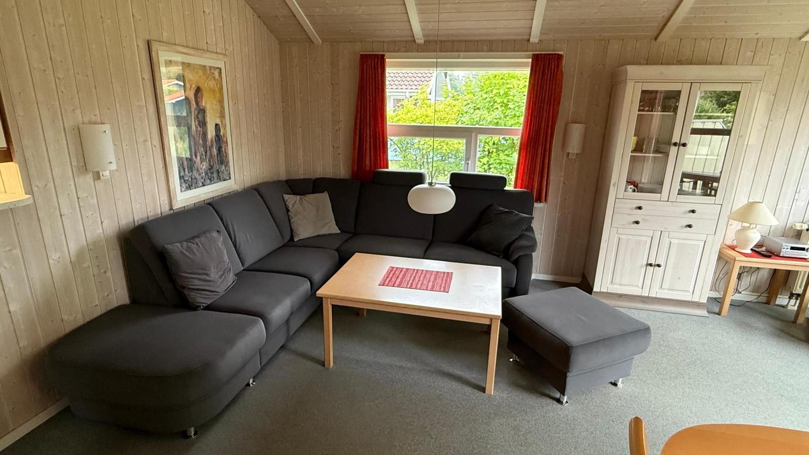 Living room with gray sofa, wooden table, and white cabinet.