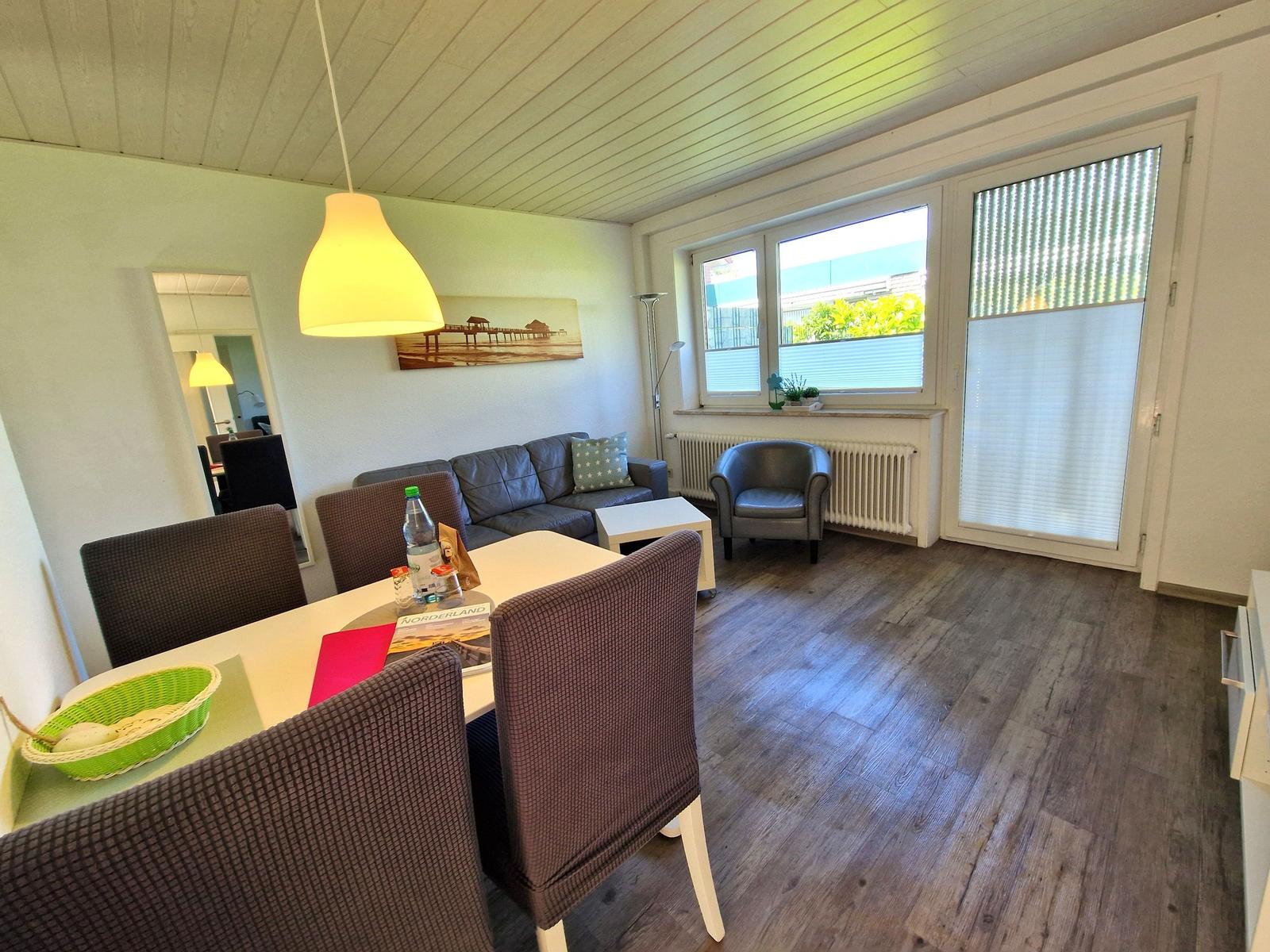 Wohn- und Essbereich mit Sofa, Stühlen und Fenster zur Aussicht.