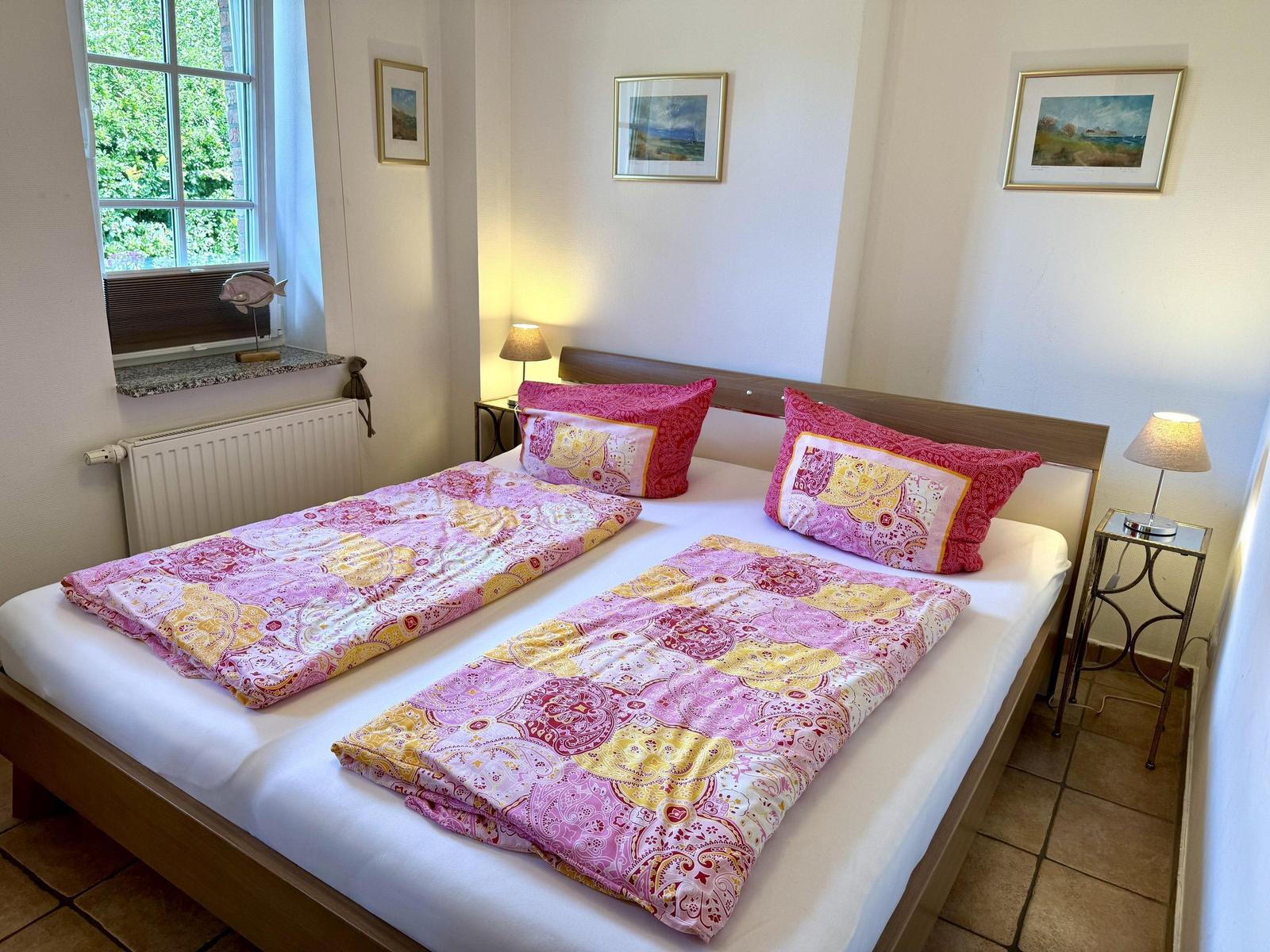 Ein Schlafzimmer mit einem Bett, zwei Nachttischen und einem Fenster.