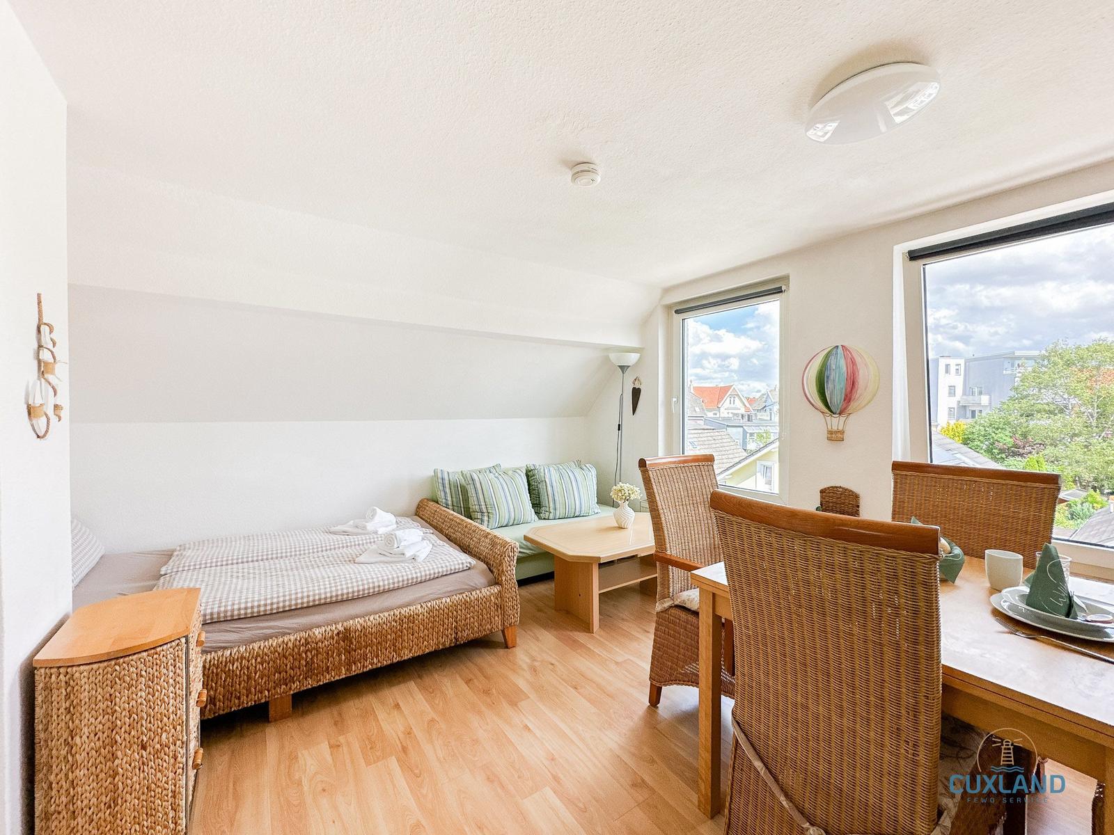 Schlafzimmer mit Bett, Sofa, Esstisch und Fenster mit Blick.