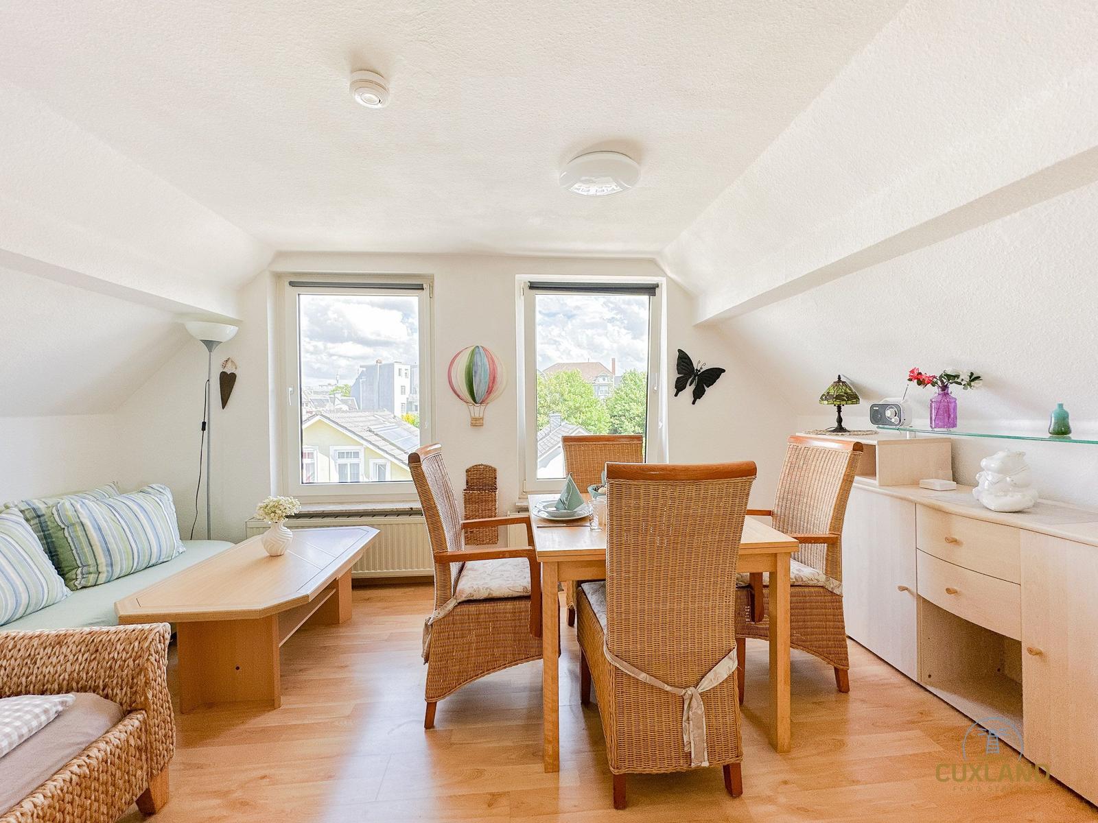 Wohn- und Essbereich mit Sitzgelegenheiten, Tisch und Stühlen sowie Fenstern mit Blick.