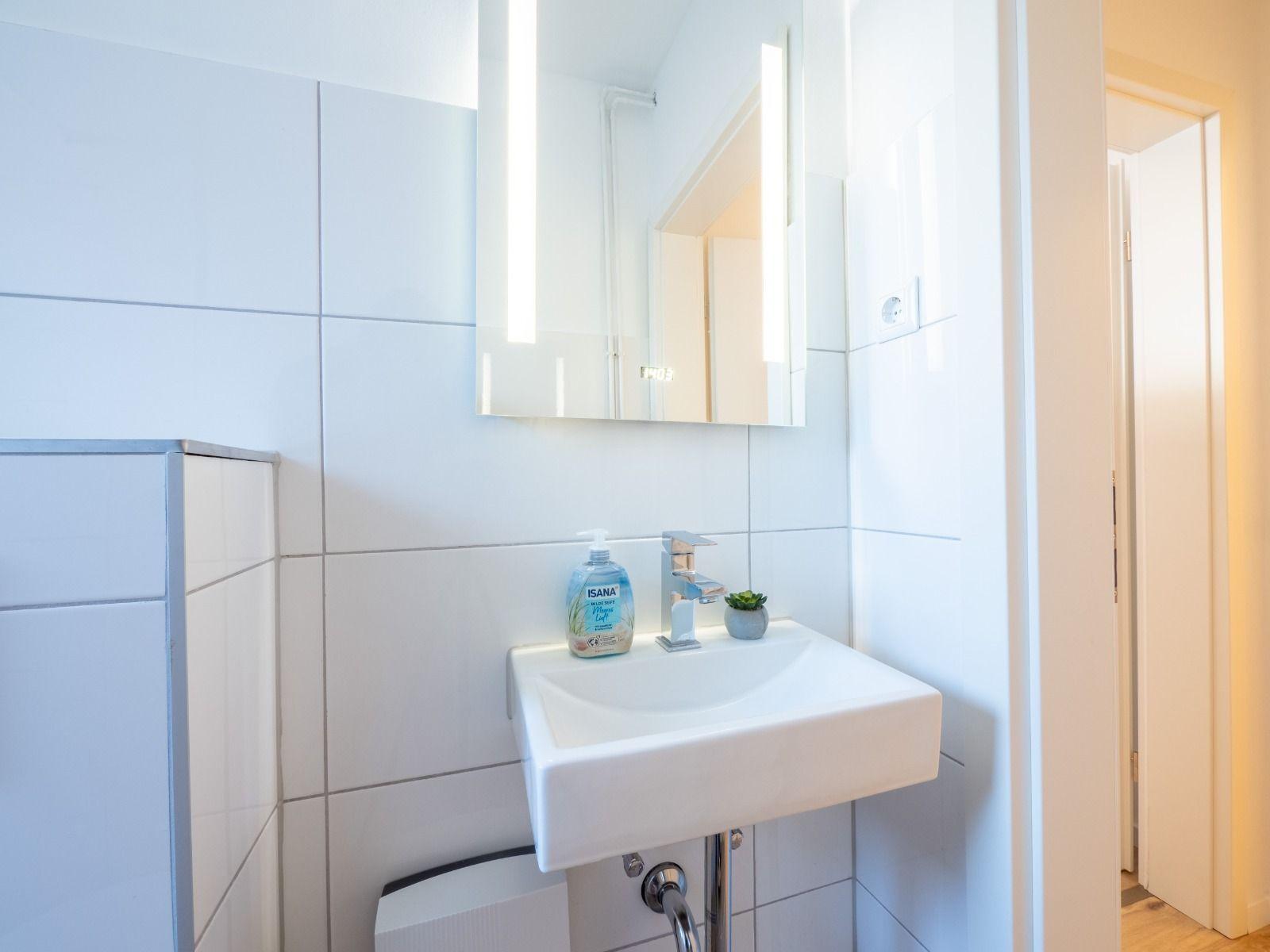 Bad mit Waschbecken, Spiegel und Seife
