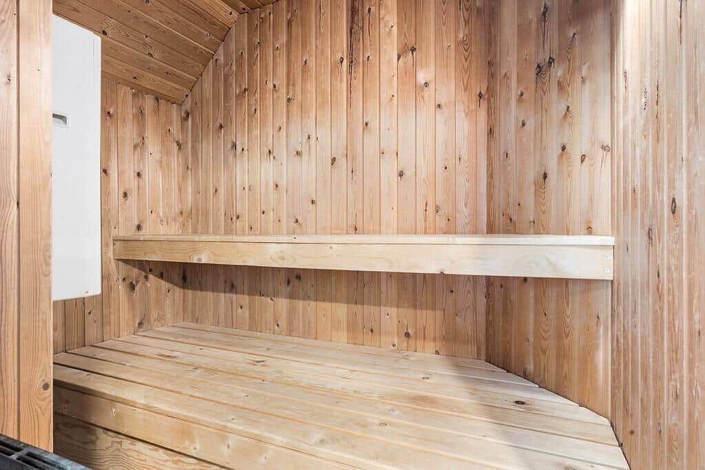 Sauna mit Holzwandverkleidung und zwei Sitzbänken.