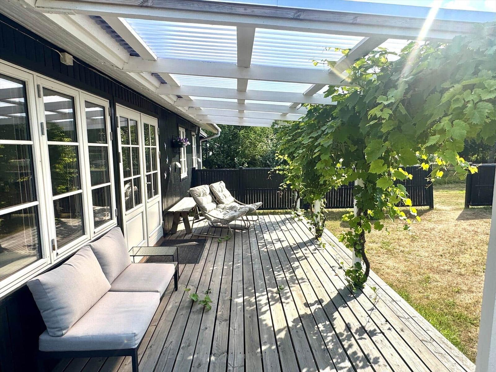 Deck with seating under roof and climbing plant