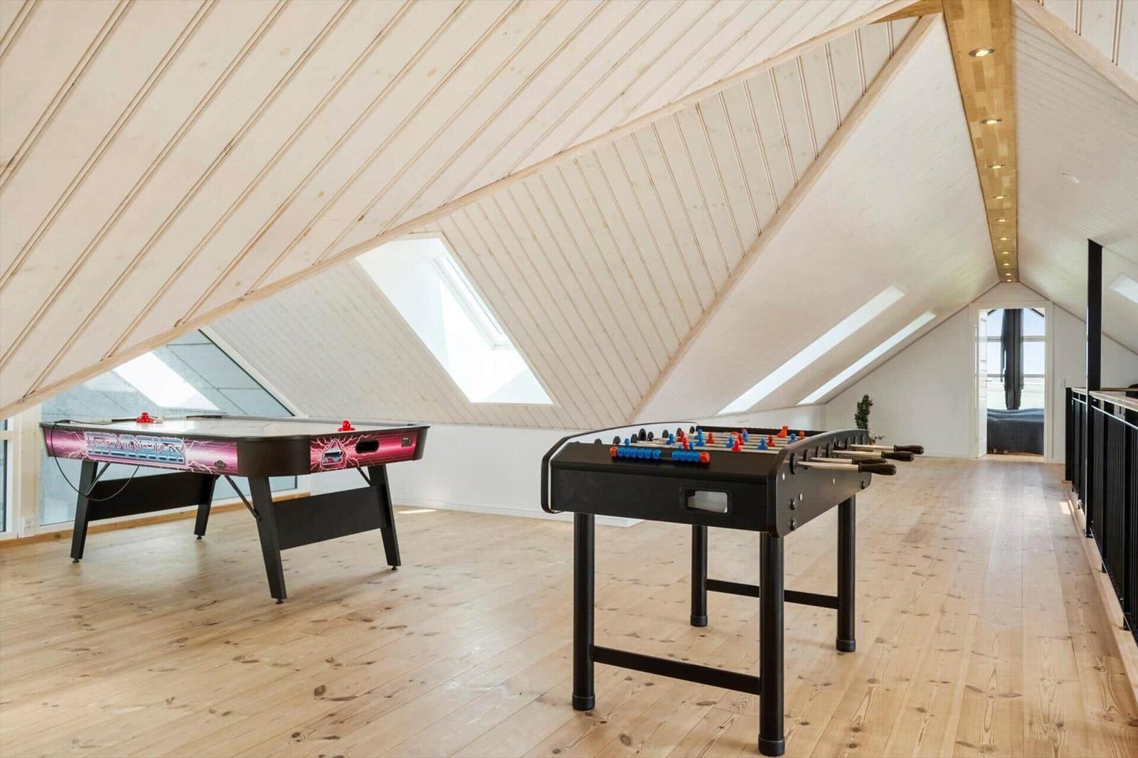 Zwei Spielplattformen in einem Dachgeschoss mit Holzboden und Dachschrägen.