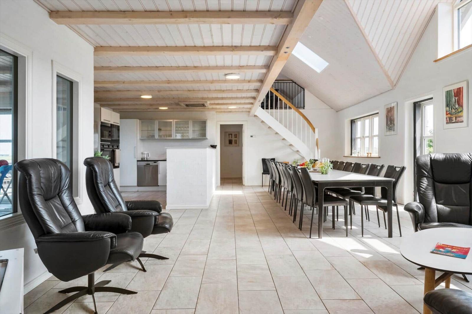 Großes Wohn- und Esszimmer mit Essbereich, Küche und Treppe.