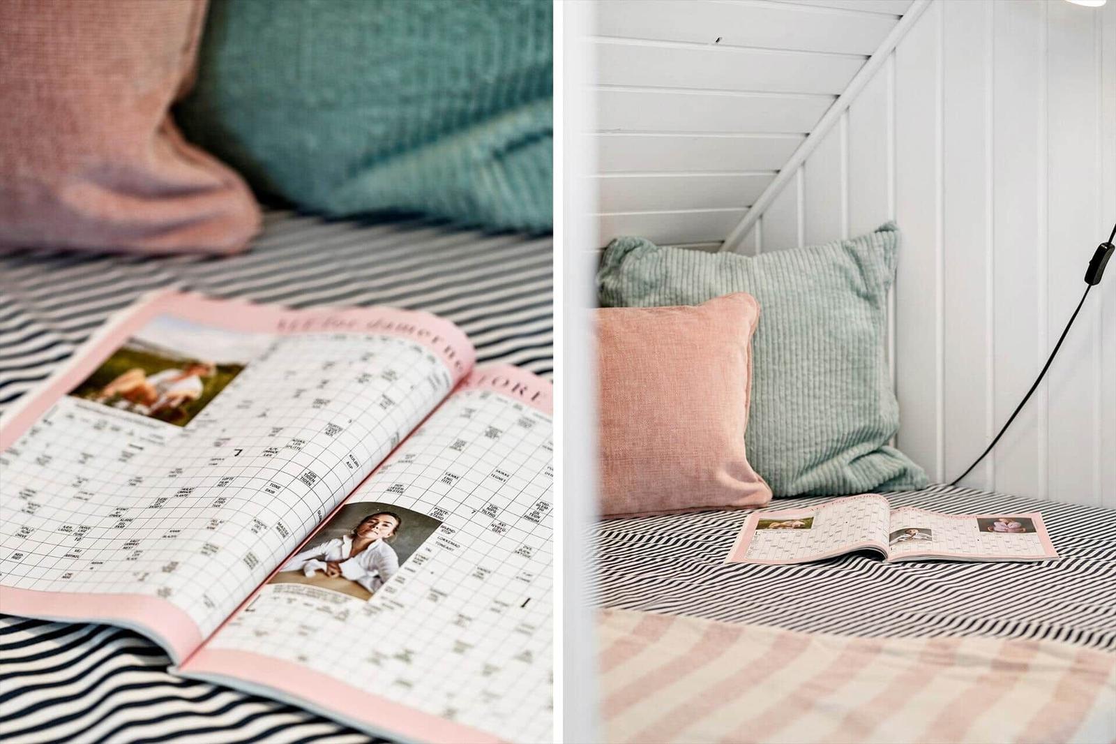 Schlafzimmer mit Kissen und Zeitschrift auf Streifenbett