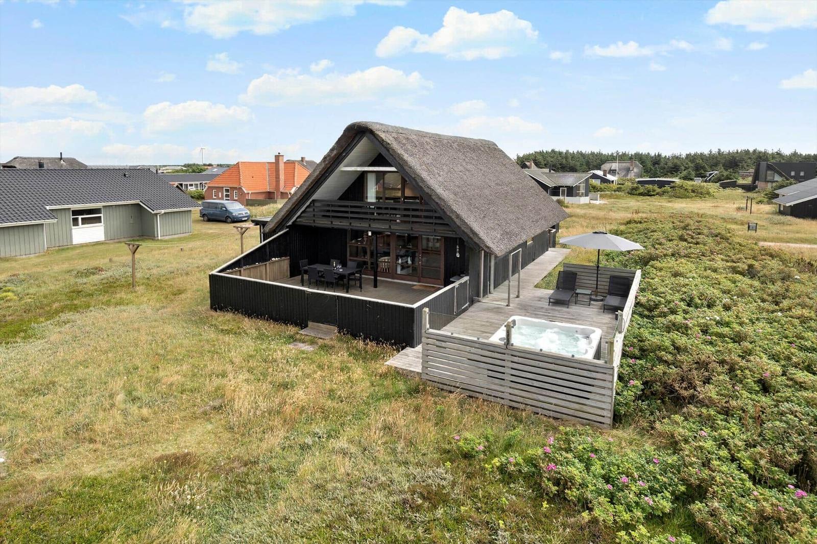 Moderne Villa mit Dachterrasse, Whirlpool und Sitzgelegenheiten im Freien.