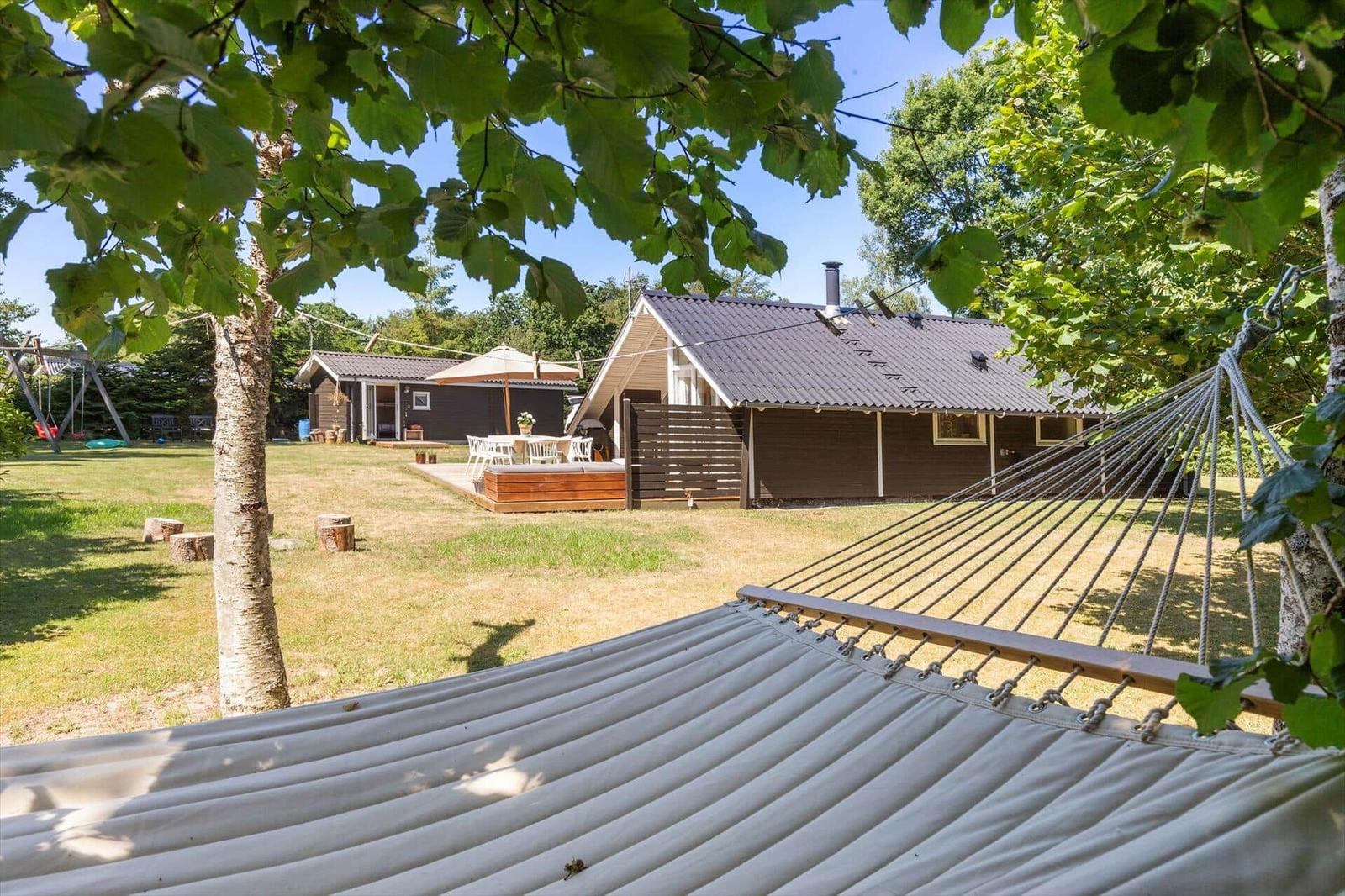 Hängemattenblick auf Ferienhaus mit Terrasse und Garten.