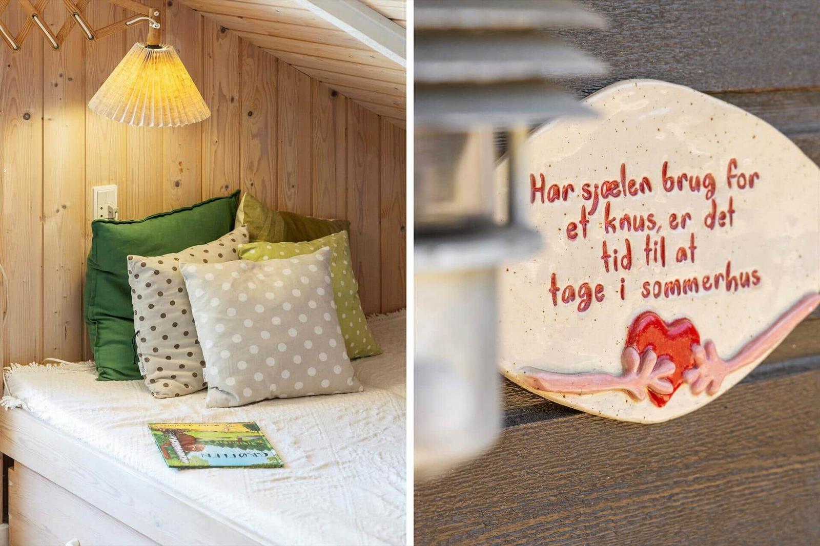 Ein gemütlicher Sitzbereich mit Kissen und einer Lampe. Eine Keramikplatte mit Dänischer Inschrift.