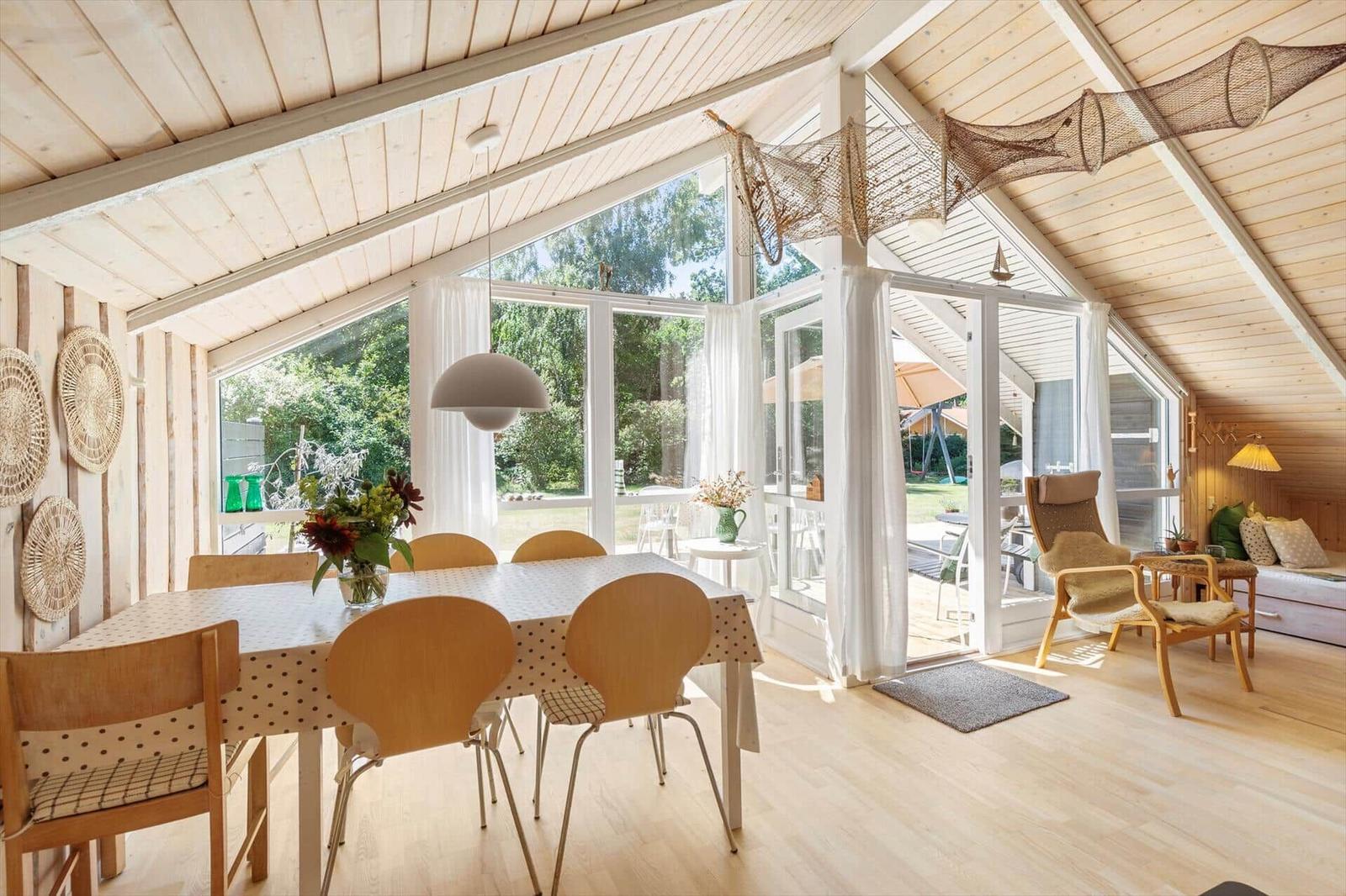 Essbereich mit Tisch und Stühlen, großes Fenster und Zugang zur Terrasse.