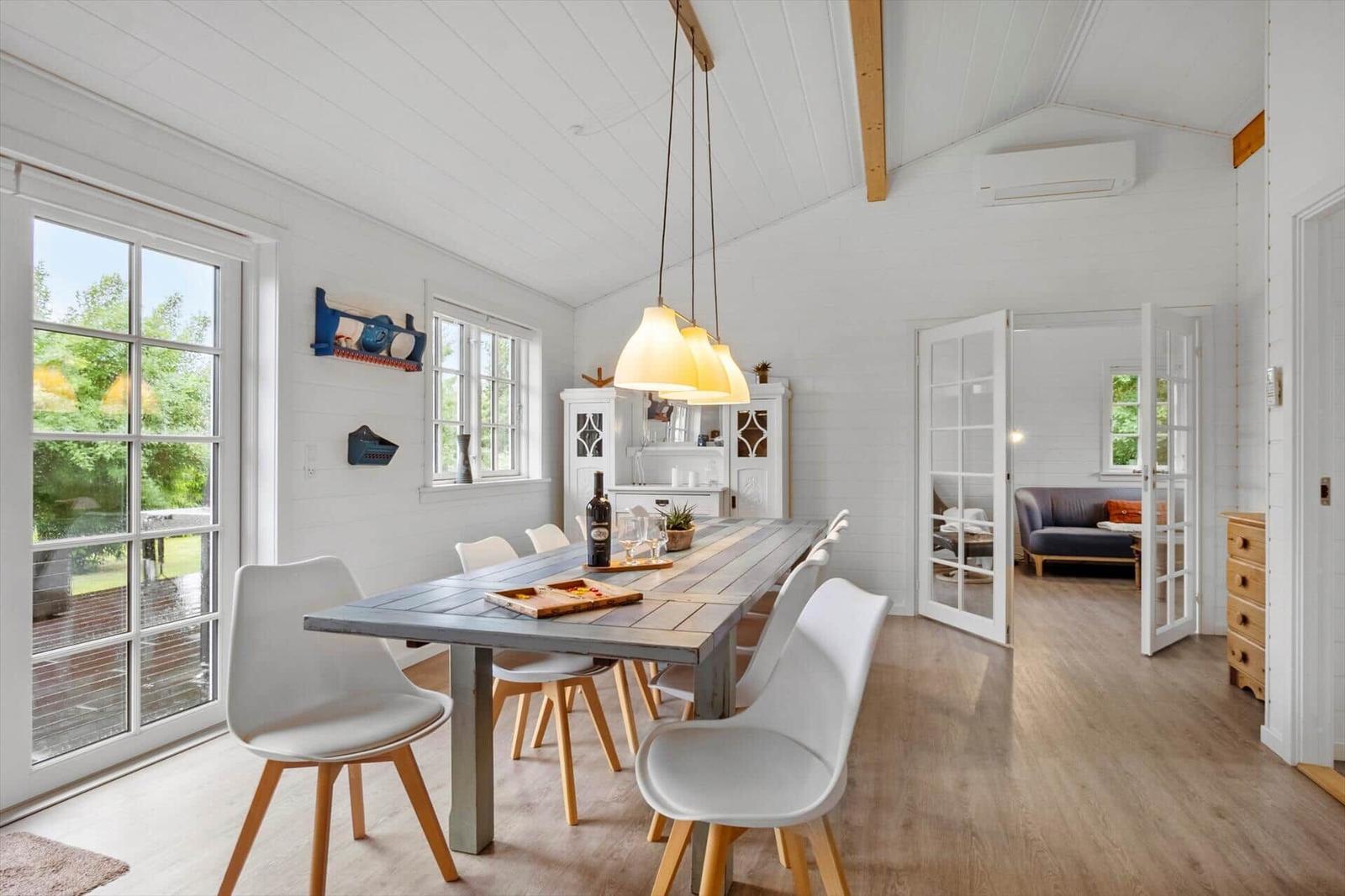 Dining room with table, chairs, and view to garden. Passage to living kitchen.