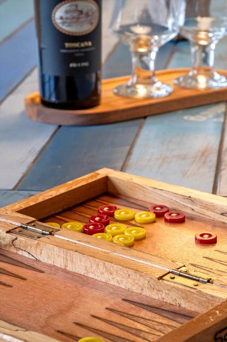 Wooden box with backgammon pieces and wine on wooden table