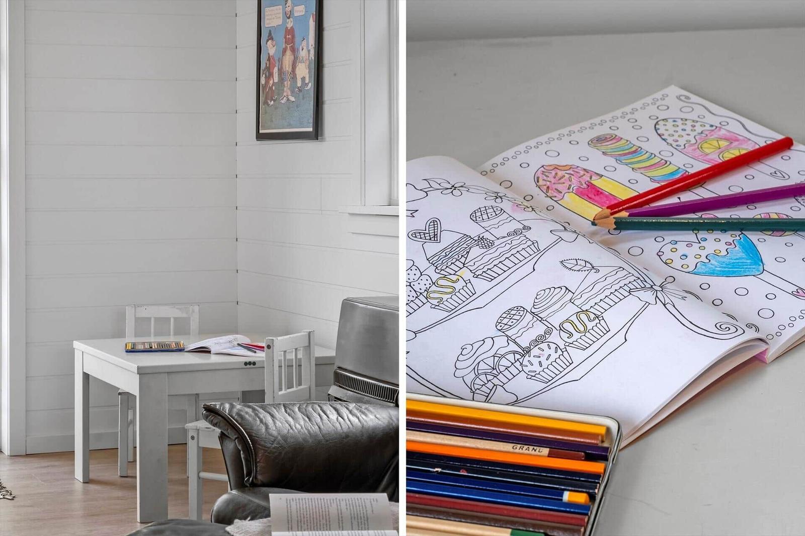 Childrens room with table, chairs, and a coloring book with colored pencils.