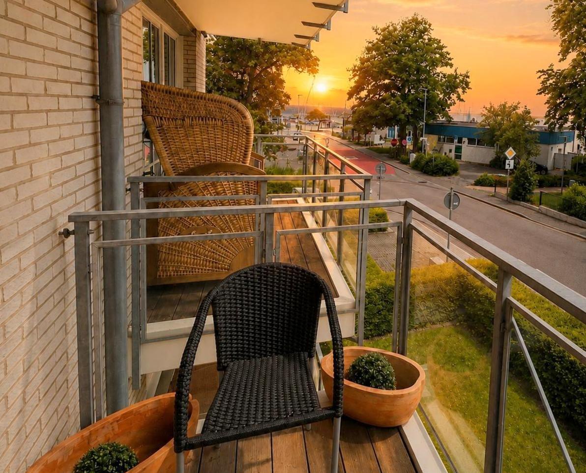 Terrace with chair and plants, view of street and sunset.