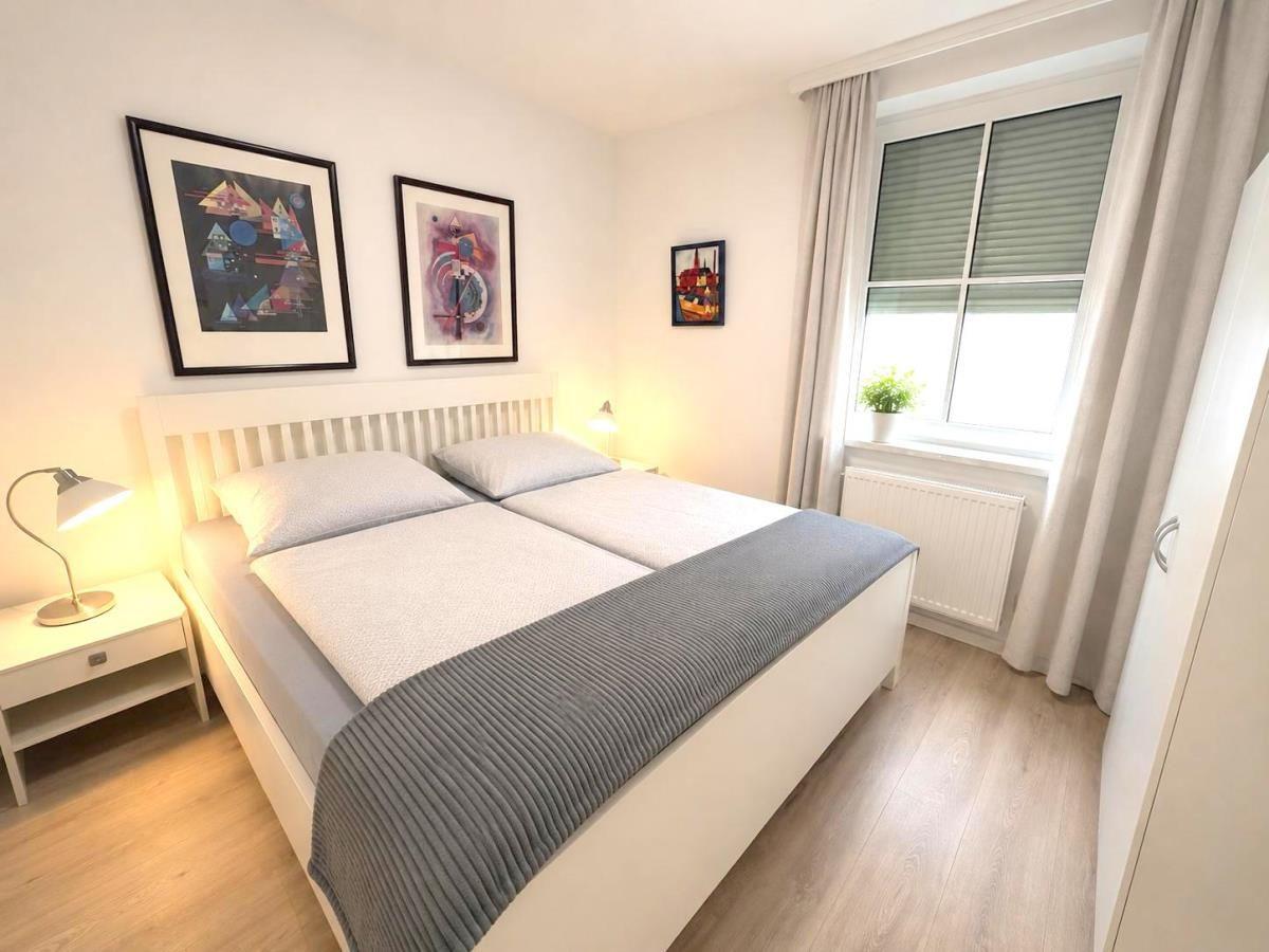 Bedroom with double bed, two nightstands, and window with blinds.