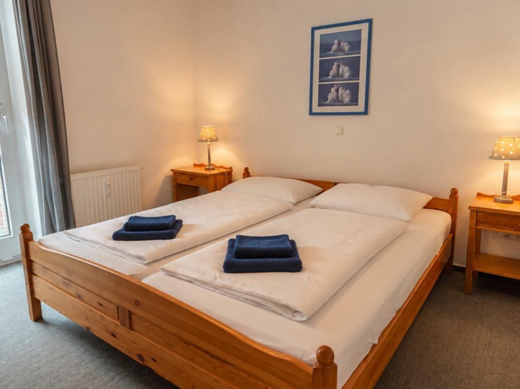 Ein Schlafzimmer mit einem Holzbett, zwei Nachttischen und einer Wanddekoration.