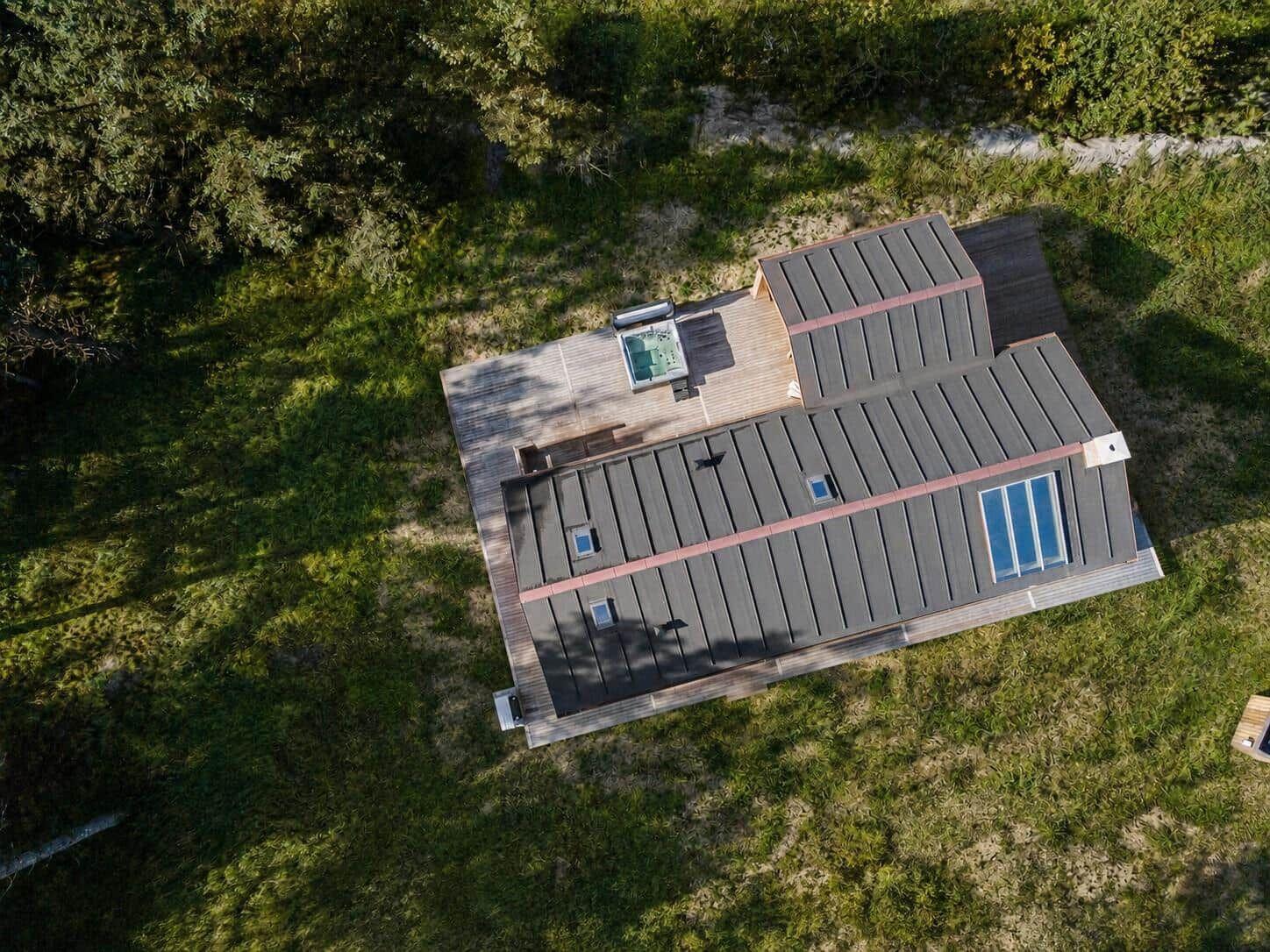 Haus mit Holzterrasse und Whirlpool in grüner Umgebung