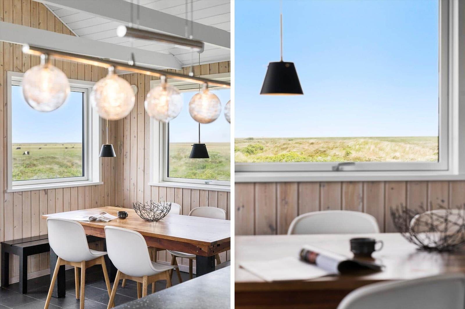 Esszimmer mit Holzwand und Blick auf Grasland